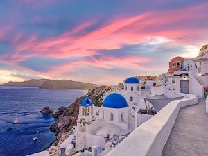 Vista nocturna de la puesta de sol del tradicional pueblo griego de Oia en la isla de Santorini en Grecia. Santorini es icónico destino de viaje en Grecia, famoso paisaje punto de puesta de sol y la arquitectura tradicional blanco.